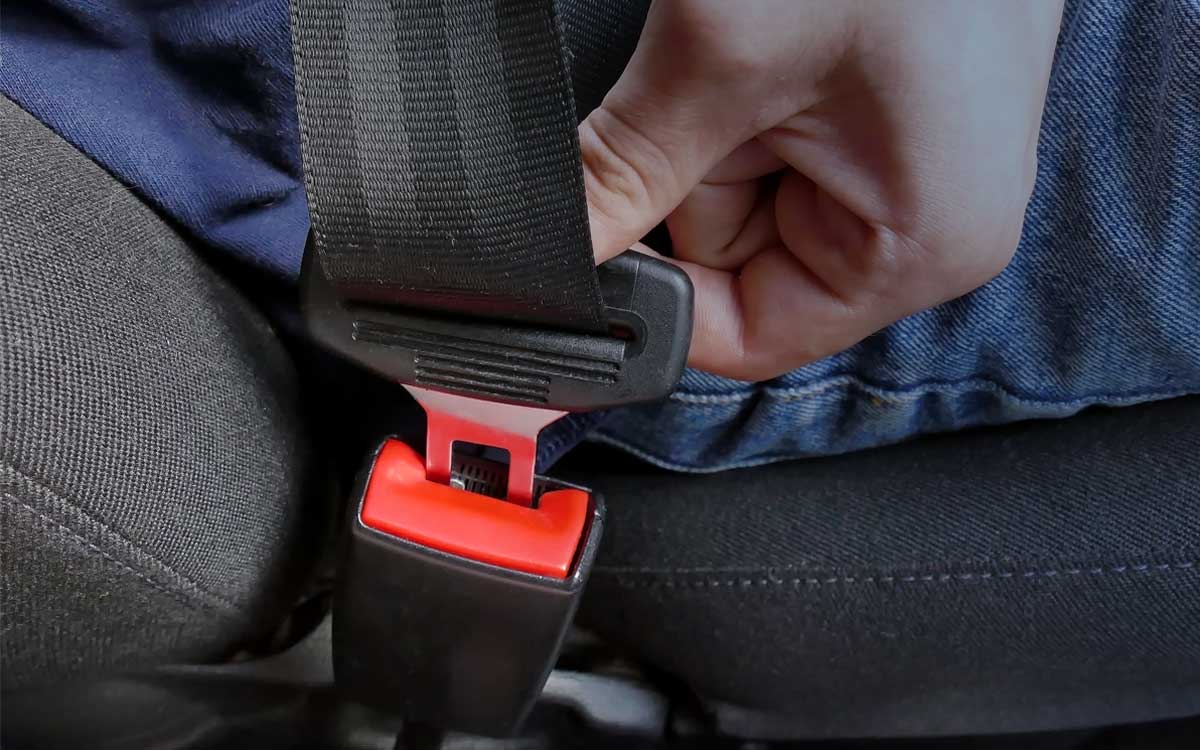 Close up shot of a person buckling his or her seat belt. Picture of a person buckling his or her seat belt