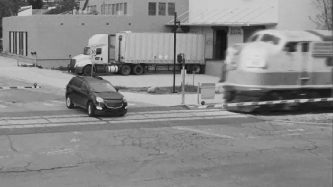 Car goes around a gate arm, train approaching Car goes around a gate arm, train approaching