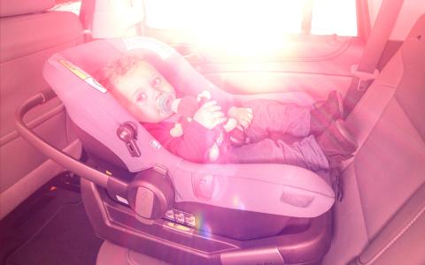 Child alone in car, sun coming in window