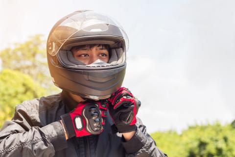 Person securing a motorcycle helmet over their head